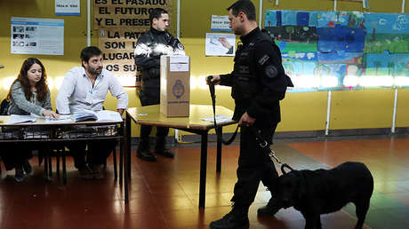 Un policía argentino camina con un perro que olfatea una posible bomba en una mesa de votación durante las elecciones primarias de mediano plazo en Buenos Aires, Argentina 13 de agosto de 2017