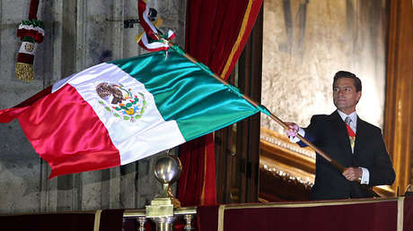 El presidente Enrique Peña Nieto ondea la bandera de México durante el acto conmemorativo de la Independencia del país.