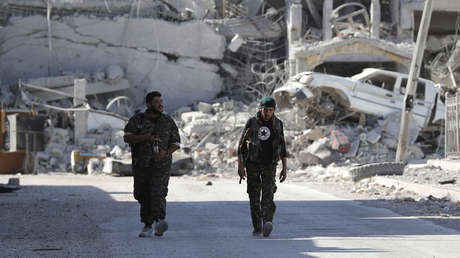 Combatientes de las Fuerzas Democráticas de Siria caminan por la línea del frente en Raqa (Siria), el 5 de octubre de 2017.