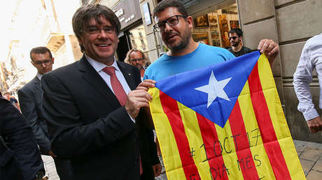 Carles Puigdemont posa junto a un partidario independentista con una estelada.
