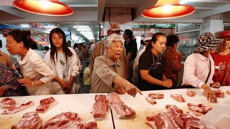 Clientes eligen piezas de cerdo en un supermercado de Shenyang, provincia de Liaoning, en China, el 11 de septiembre de 2007.