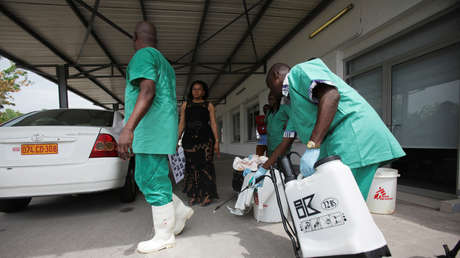 A health worker sprays the disinfectant on his colleague in Kinshasa on October 21, 2014