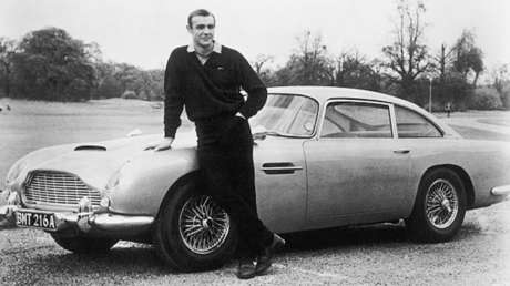 El actor Sean Connery durante el rodaje de 'Goldfinger' al lado de un Aston Martin DB5 de 1964.
