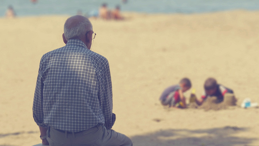 "Seguro fue un gran amor": La foto viral del hombre que lleva el retrato de su esposa muerta al mar