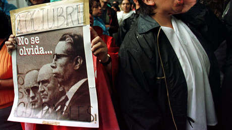 Una mujer protesta con una fotografía con expresidentes señalados por la matanza de Tlatelolco. Ciudad de México, 2 de octubre de 1998. 