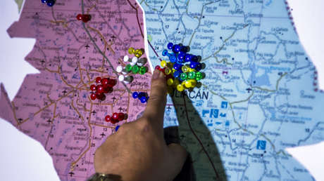 Un hombre señala un mapa de Culiacán, en Sinaloa, que muestra los puntos donde operaba el cártel presuntamente encabezado por Joaquín Guzmán Loera.