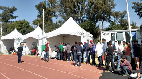 Migrantes aguardan en una fila para recibir atención médica en las carpas habilitadas para dicho fin.