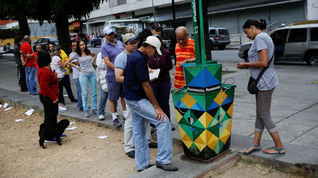 Gente haciendo cola para cargar sus teléfono en un panel solar en una calle de Caracas, Venezuela, 10 de marzo de 2019.