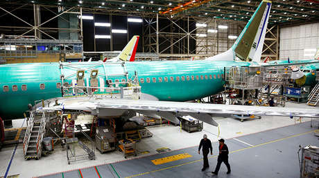 Trabajadores bajo un avión 737 Max en la fábrica de Boeing en Renton, EE. UU., 27 de marzo de 2019.