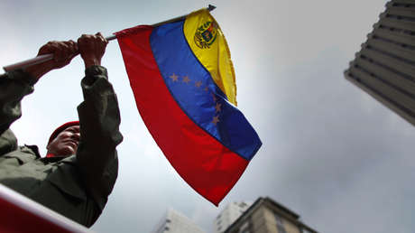 Un trabajador venezolano ondea la bandera de su país en Caracas, en mayo de 2012.