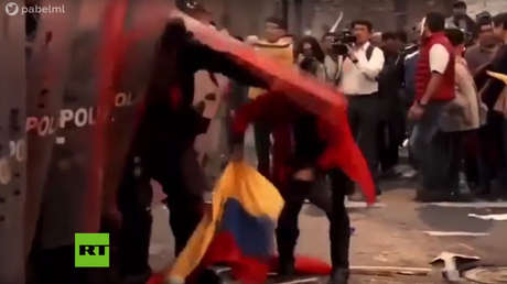 Un miembro de la Policía Nacional de Ecuador golpea a patadas a una mujer, el 16 de abril del 2019, en Quito.