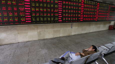 Un hombre echa una siesta en una oficina de corretaje, Pekín, China.