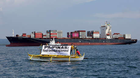 Activistas de Greenpeace extienden una pancarta frente al barco con 69 contenedores en Manila, Filipinas. 30 de mayo de 2019.