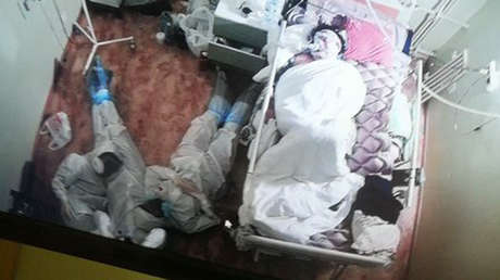 Tres sanitarios rusos se acuestan en el suelo tras una noche en vela junto a la cama de una paciente con covid-19 (FOTO)
