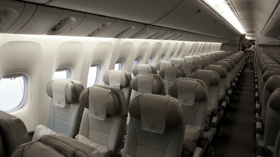 A passenger flying in a full plane pulls around with a bundle of corn