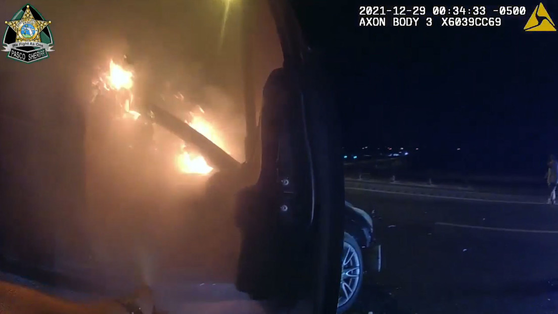 Policías rescatan a una mujer que quedó atrapada en su auto envuelto en llamas tras ocasionar un accidente  (VIDEO)