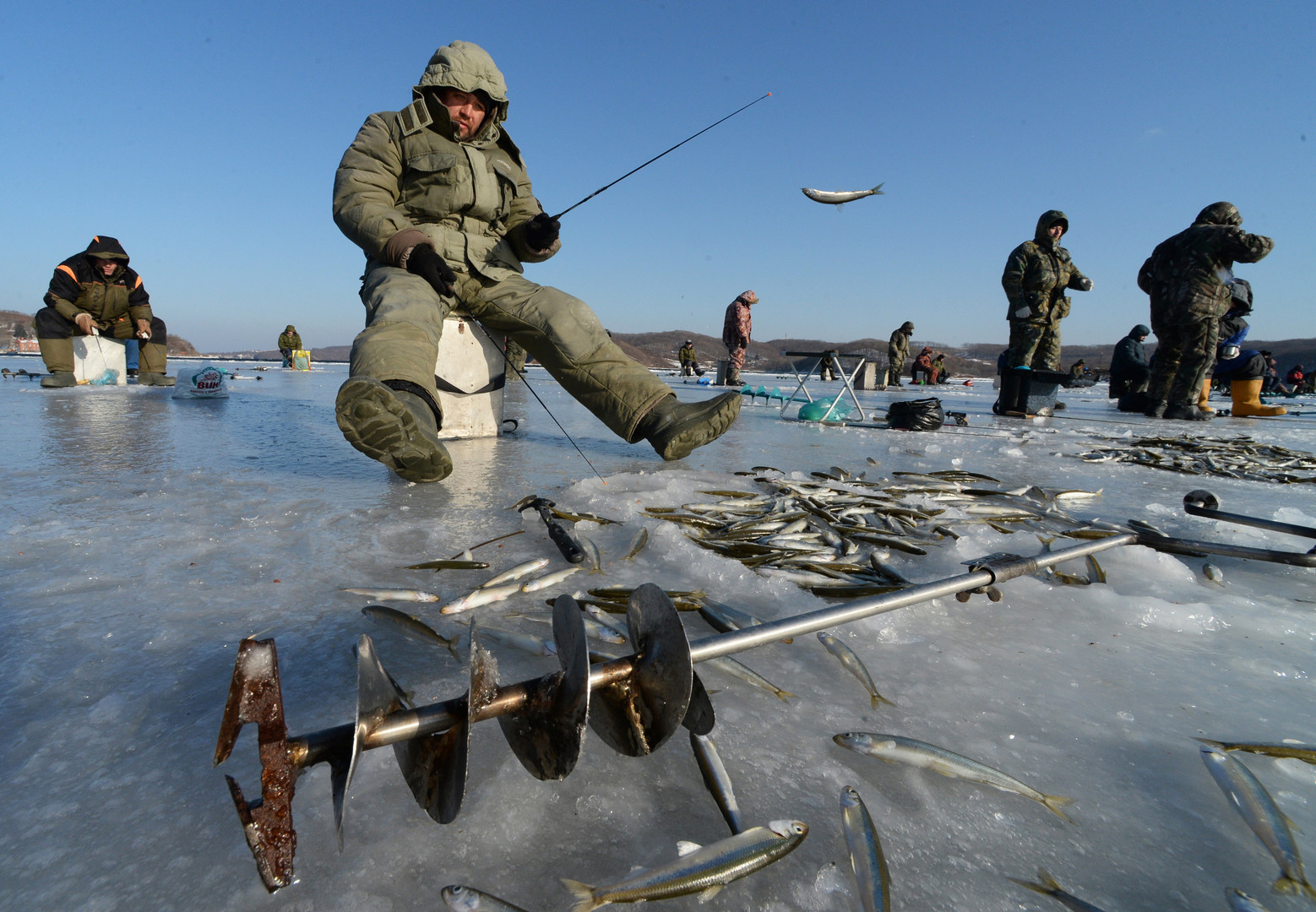 Подледный лов рыбы. Зимняя рыбалка на льду. Рыбаки на льду. Рыбак зимой.