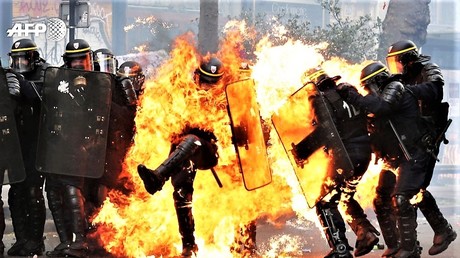 Ausschreitungen in Paris. Polizisten brennen und setzen Tränengas ein.