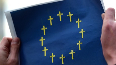 Ein Aktivist von Amnesty International hält ein Bild der europäischen Flagge hoch, das aus Trauerkreuzen besteht anstelle der gewöhnlichen goldenen Sterne.