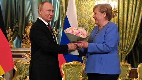 Kavalier der alten Schule: Wladimir Putin reicht deutscher Kollegin Angela Merkel Begrüßungsstrauß