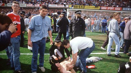 Rescuers help soccer fans at Hillsborough stadium in Sheffield on April 15, 1989 when 96 fans of Liverpool Football Club were crushed to death and hundreds injured after support railings collapsed during an FA Cup semi-final between Liverpool and Nottingham Forest. © AFP