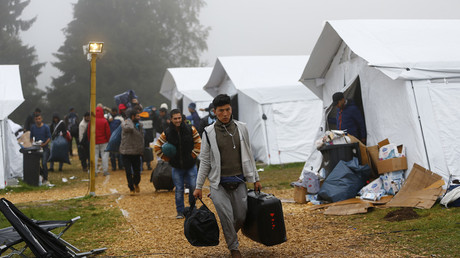 Migrants make their way to buses to travel to a different shelter, from a temporary registration centre in the village of Schwarzenborn, northeast of Frankfurt, Germany © Kai Pfaffenbach