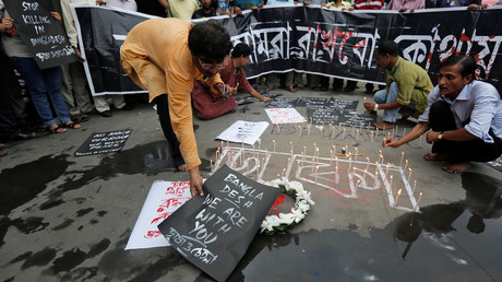A man places a sign as others light candles during a vigil in Kolkata, India, to show solidarity with the victims of the attack at Holey Artisan restaurant after Islamist militants attacked the upscale cafe in Dhaka, Bangladesh, July 2, 2016. © Rupak De Chowdhuri