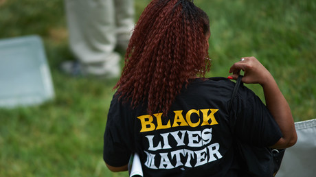 A woman wears a shirt with 'Black Lives Matter' during a memorial service for slain 18 year-old Michael Brown Jr. on August 9, 2015 at the Canfield Apartments in Ferguson, Missouri. © Michael B. Thomas