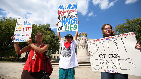 Protesters hold signs outside the U.S. District Court in Washington, where a hearing was being held to decide whether to halt construction of an oil pipeline in parts of North Dakota where a Native American tribe says it has ancient burial and prayer sites, September 6, 2016. © Kevin Lamarque