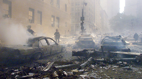 Cars smolder in the street as the destroyed World Trade Center burns in New York on September 11, 2001 © Reuters