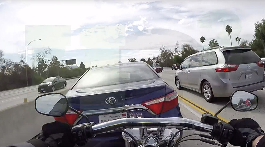 Biker lands on top of car after bizarre freeway collision (VIDEO)