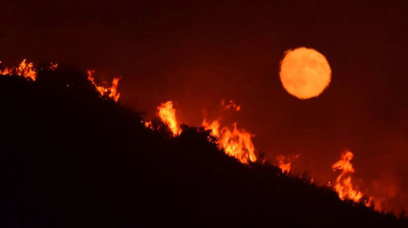 The full moon rises over flames of the Alamo fire on a hilltop off Highway 166 east of Santa Maria, California, U.S. July 7, 2017. © Mike Eliason