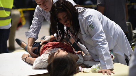 An injured woman is helped after a powerful quake in Mexico City on September 19, 2017. © Pedro Pardo / AFP