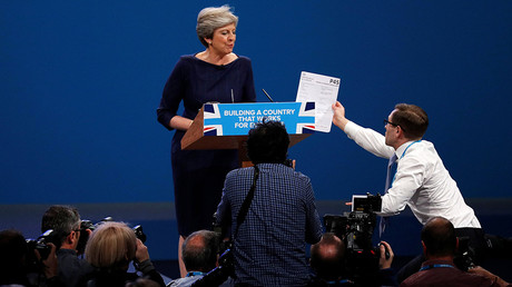 A member of the audience hands a P45 form (termination of employment tax form) to Britain's Prime Minister Theresa May as she addresses the Conservative Party conference in Manchester, October 4, 2017. Phil Noble © Reuters