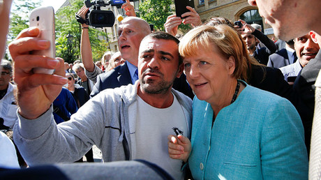 A migrant takes a selfie with German Chancellor Angela Merkel outside a refugee camp near the Federal Office for Migration and Refugees after registration at Berlin's Spandau district, Germany. © Fabrizio Bensch