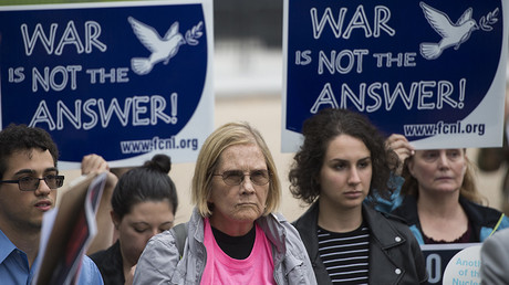 People hold up signs during a protest calling for the Trump administration to continue diplomacy with Iran near the White House in Washington, DC on October 12, 2017 © Andrew Caballero-Reynolds