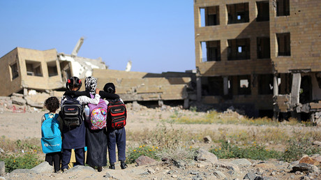 Yemeni school girls look at a school on March 16, 2017, that was damaged in an air strike in the southern Yemeni city of Taez  © Ahmad Al-Basha