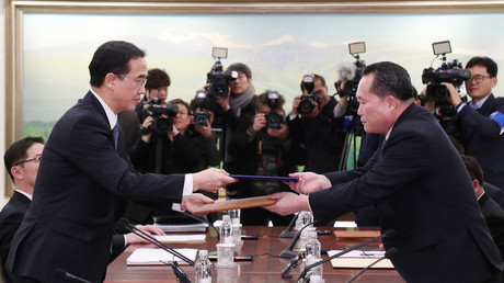 Ri Son Gwon exchanges documents with Cho Myoung-gyon, January 9, 2018.  © Yonhap 