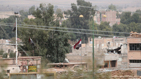 FILE PHOTO Syrian national flags flutter at the governorate building in the northeastern city of Hasaka © Rodi Said