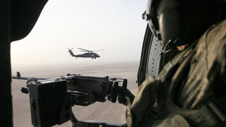 FILE PHOTO: A U.S. soldier holds a machine gun in a U.S. helicopter flying over Samarra, Iraq © Thaier Al-Sudani