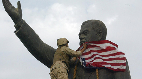 FILE PHOTO: A US Marine covers the face of Iraqi President Saddam Hussein's statue with the US flag in Baghdad's al-Fardous square © Ramzi Haidar