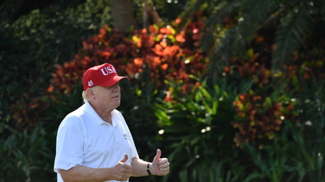 Trump practices his golf swing as Americans march for gun control
