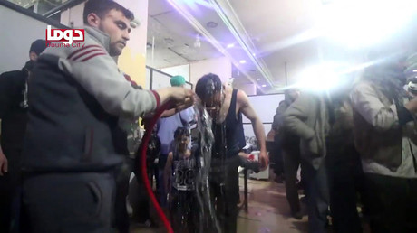 An image grab taken from a video released by the Douma City Coordination Committee shows unidentified volunteers spraying a man with water at a make-shift hospital following an alleged chemical attack on the rebel-held town of Douma on April 7, 2018 © AFP