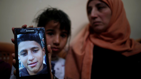 The mother of Mohammed Ayoub shows her son's photo. © Mohammed Salem 