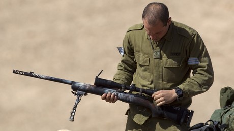 An Israeli army sniper cleans his gun after an exercise in the Negev Desert, January 31, 2012 / JACK GUEZ