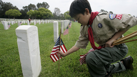 Boy Scout places a flag at a gravesite of a US military veteran © Jonathan Alcorn