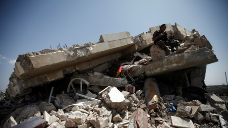 A police trooper sits on the wreckage of a house hit by air strikes on an outskirt of Sanaa, Yemen May 10, 2018.  © Mohamed al-Sayaghi