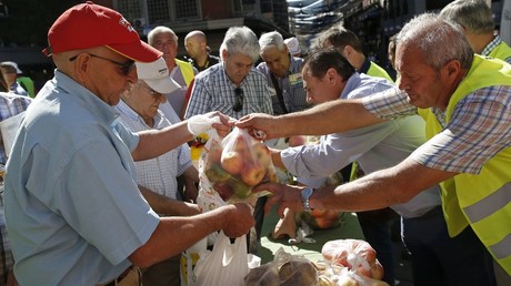 People take fruits and vegetables given away in central Madrid by Spanish farmers to protest against Russia's ban on vegetables, meat, fish, milk and dairy imports from the European Union © Andrea Comas