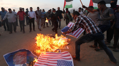 Palestinian demonstrators burn representations of US flags and a poster of Donald Trump in the southern Gaza Strip May 15, 2018. © Ibraheem Abu Mustafa