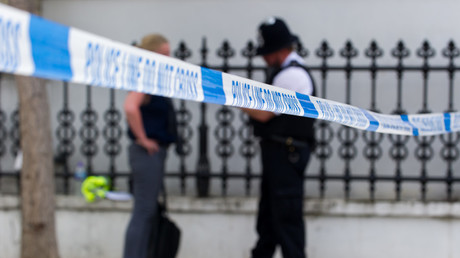 A police officer talks with a neighbour near the crime scene of yet another London stabbing. © Gustavo Valiente